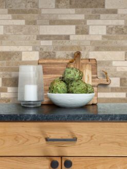 black granite countertop with brown cabinets and travertine backsplash tile