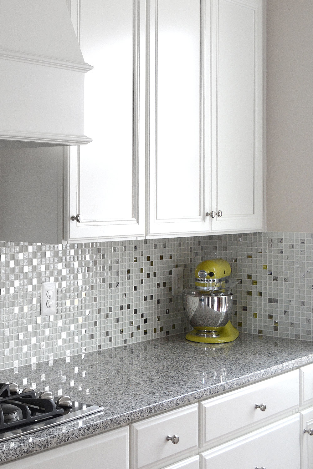 White and gray tones, white kitchen cabinets gray Luna Pearl kitchen granite countertop with white glass metal kitchen backsplash tile. #whitebacksplash #whitekitchen #whitecabinet #glassbacksplash #metalbacksplash #modernbacksplash