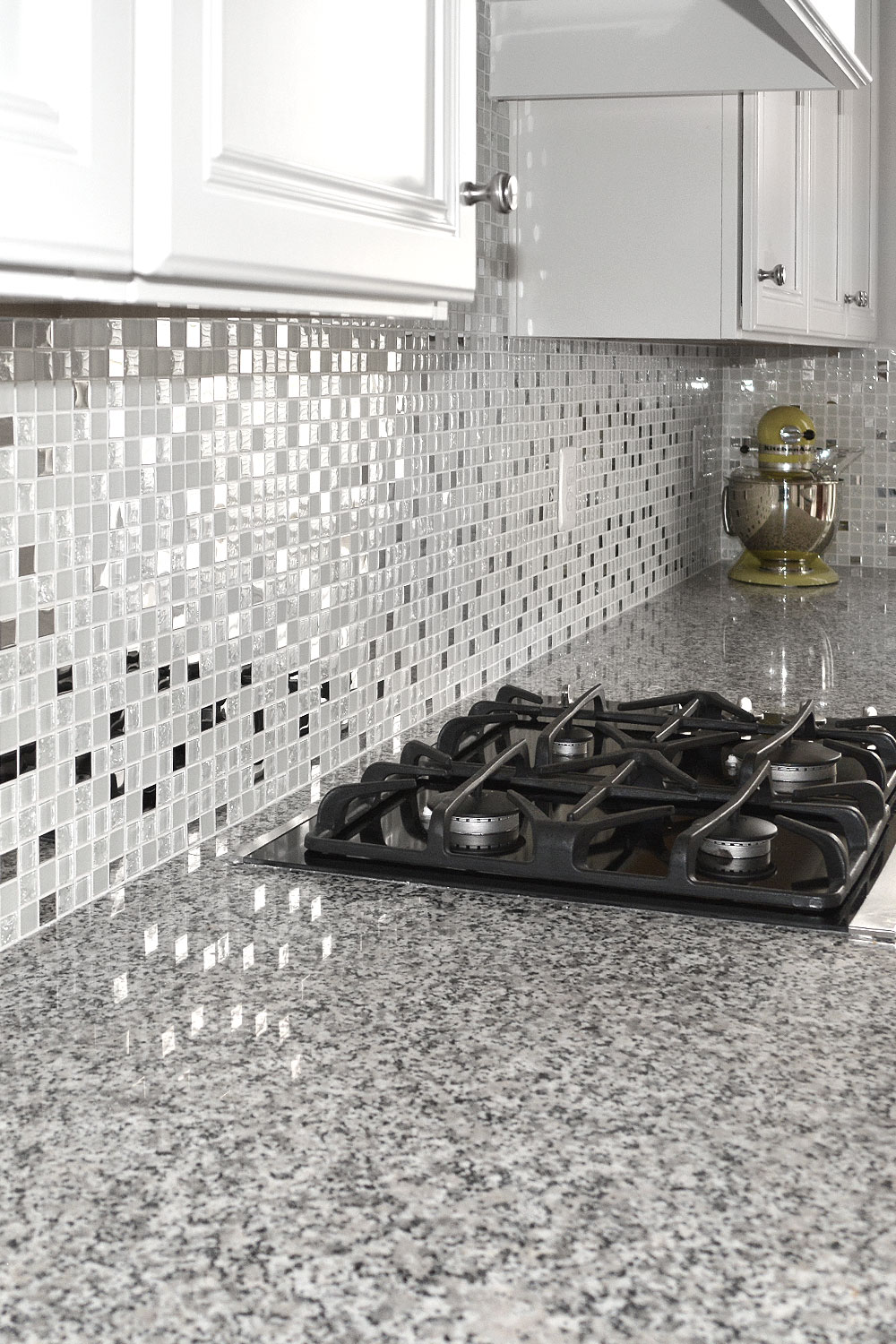 White kitchen cabinets, Luna pearl gray granite countertop with glass and metal mixed backsplash tile. #whitebacksplash #whitekitchen #whitecabinet #glassbacksplash #metalbacksplash #modernbacksplash