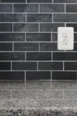 new caledonia granite countertop with black slate subway backsplash tile BA1070