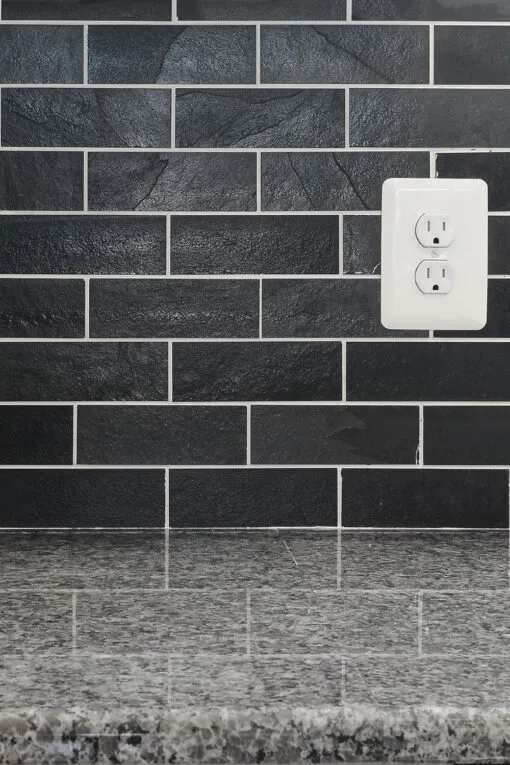 new caledonia granite countertop with black slate subway backsplash tile BA1070